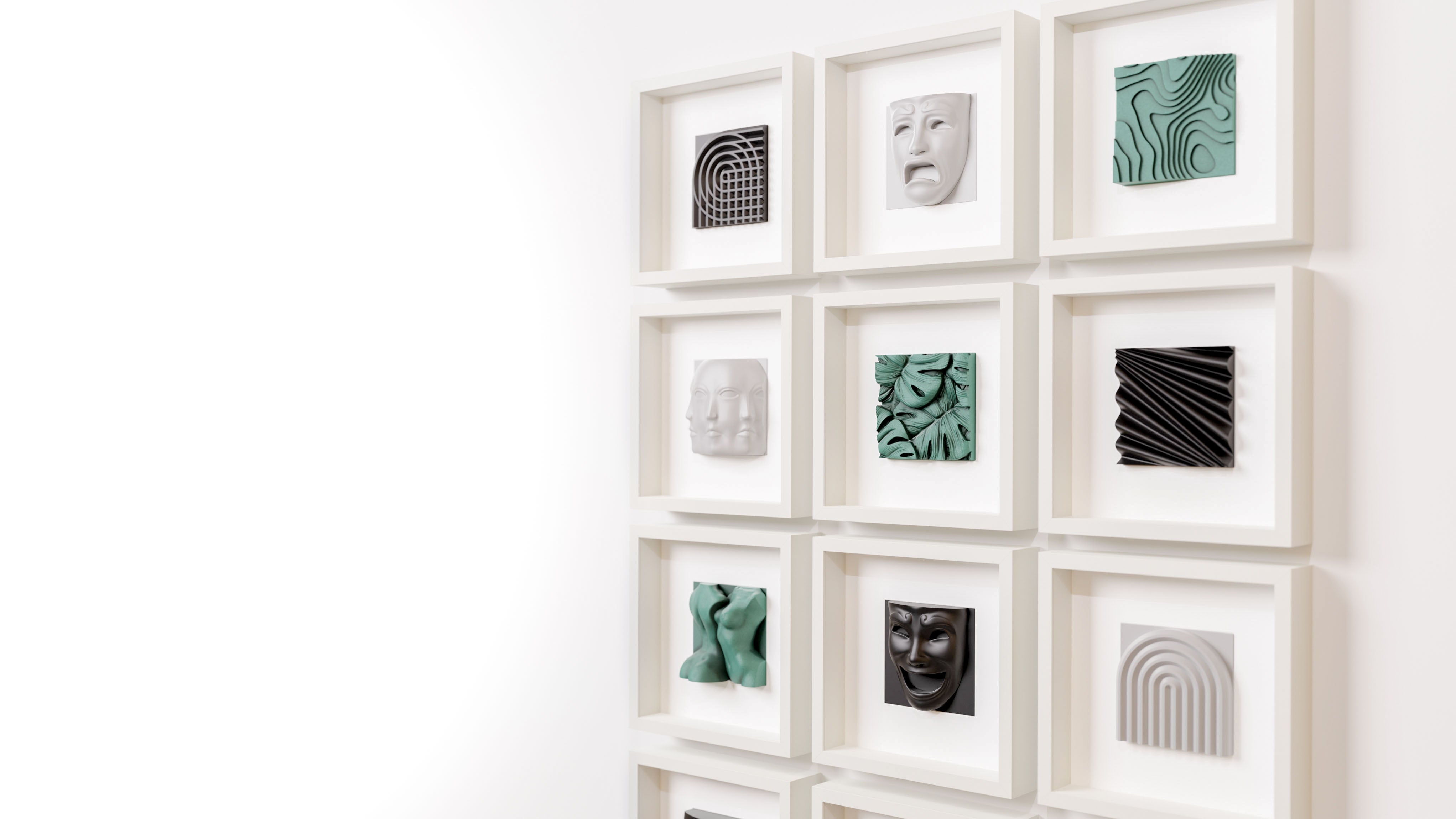 Grid display of white shadowbox frames featuring a curated selection of sculptural artworks in matte black, old patina green, and marble white finishes. This collection highlights diverse designs, including geometric patterns, layered foliage, and expressive masks, arranged to create a visually dynamic and modern presentation.