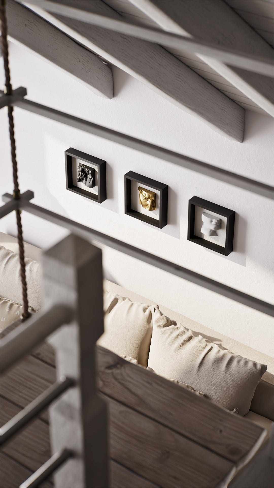 A cozy living room setup with a light beige sofa adorned with patterned cushions, set against a white wall featuring three black shadowbox frames displaying elegant sculptures in black, gold, and white. The space is complemented by a wooden table in the foreground and exposed beam ceilings, creating a warm and inviting atmosphere.