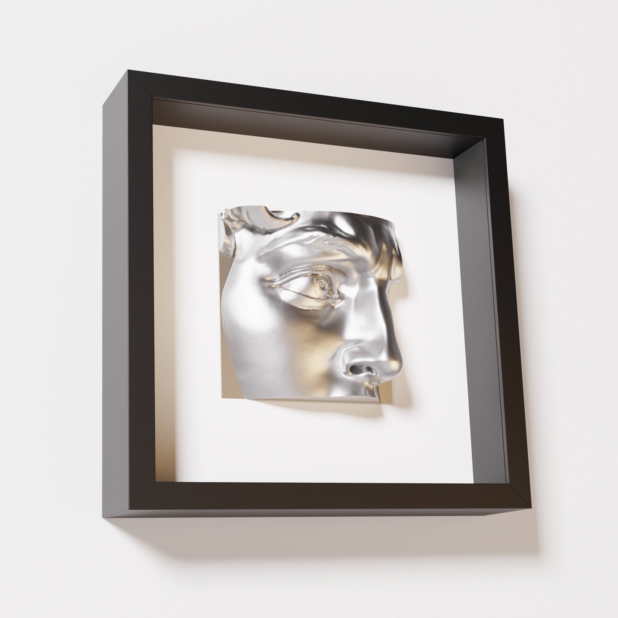 A close-up of a black shadowbox frame containing a chrome silver sculpture of 'David's Eye,' highlighting the intricate details of the eye, brow, and surrounding textures.