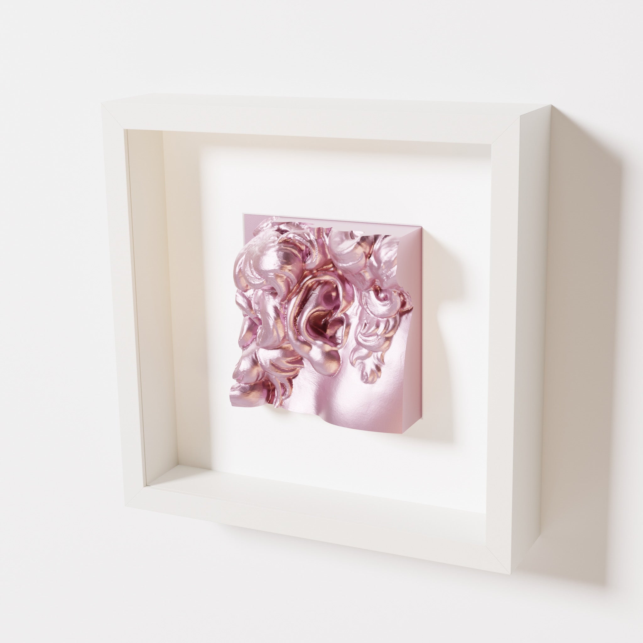 A close-up of a white shadowbox frame holding a metallic rose sculpture of 'David's Ear.' The soft pink metallic finish highlights the detailed ear and curls with a contemporary touch.