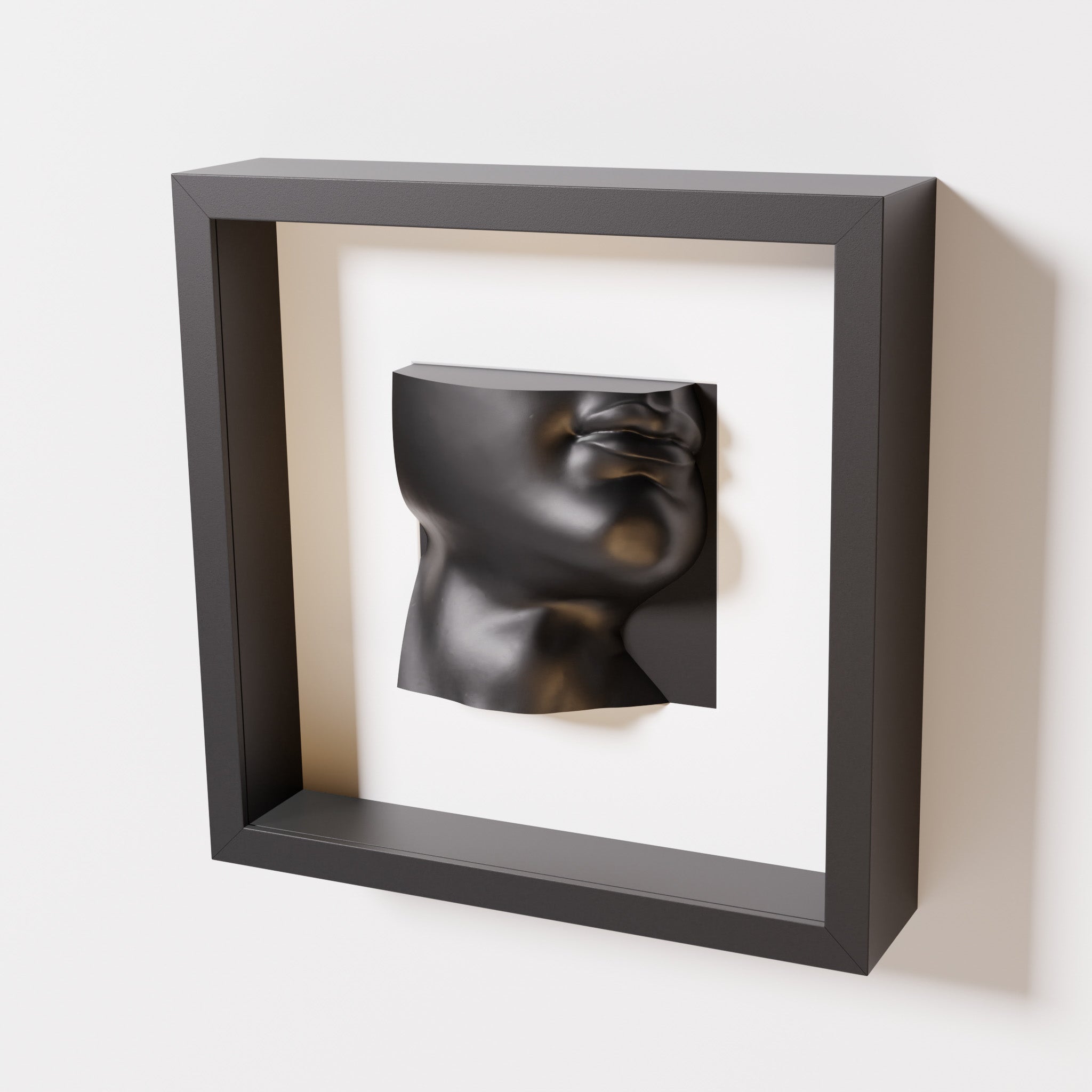 A close-up of a black shadowbox frame containing a matte black sculpture of 'David's Lip,' highlighting the detailed lips, chin, and surrounding textures of Michelangelo's David.