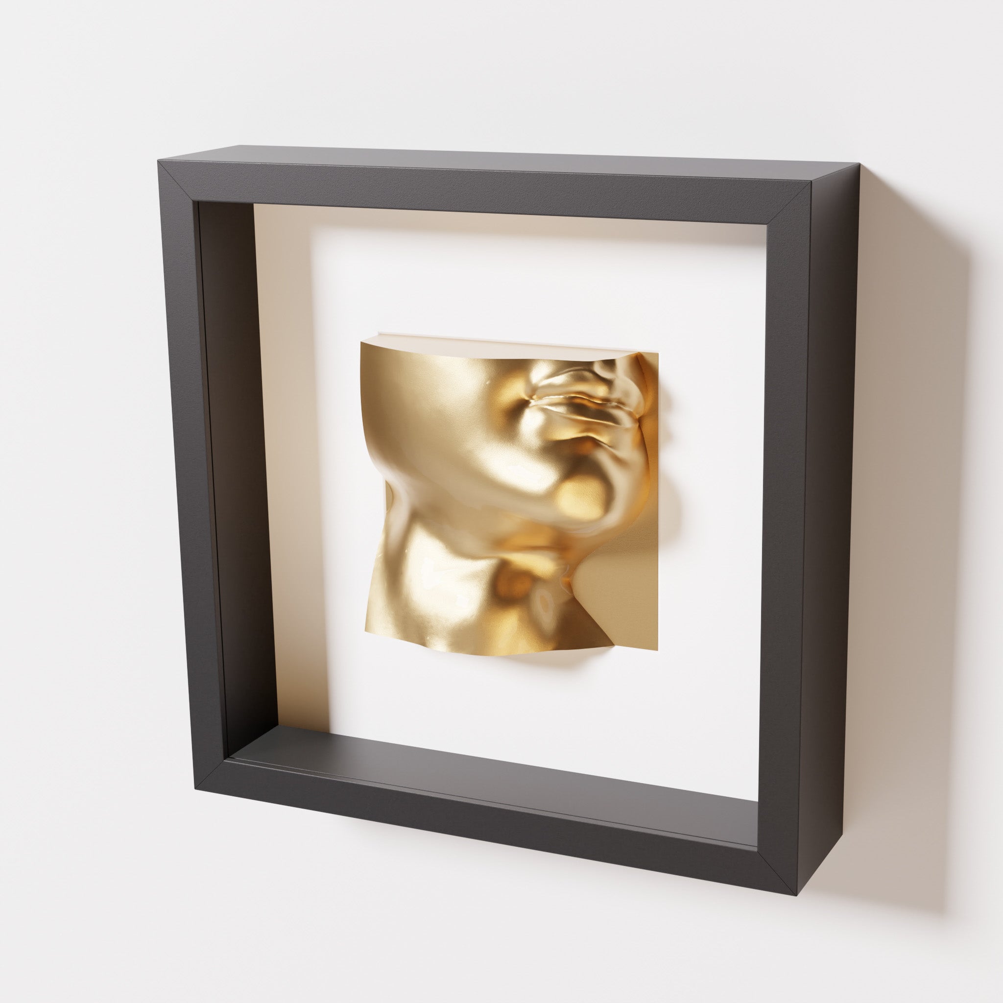 A close-up of a black shadowbox frame containing a chrome gold sculpture of 'David's Lip,' highlighting the detailed lips, chin, and reflective gold finish inspired by Michelangelo's David.