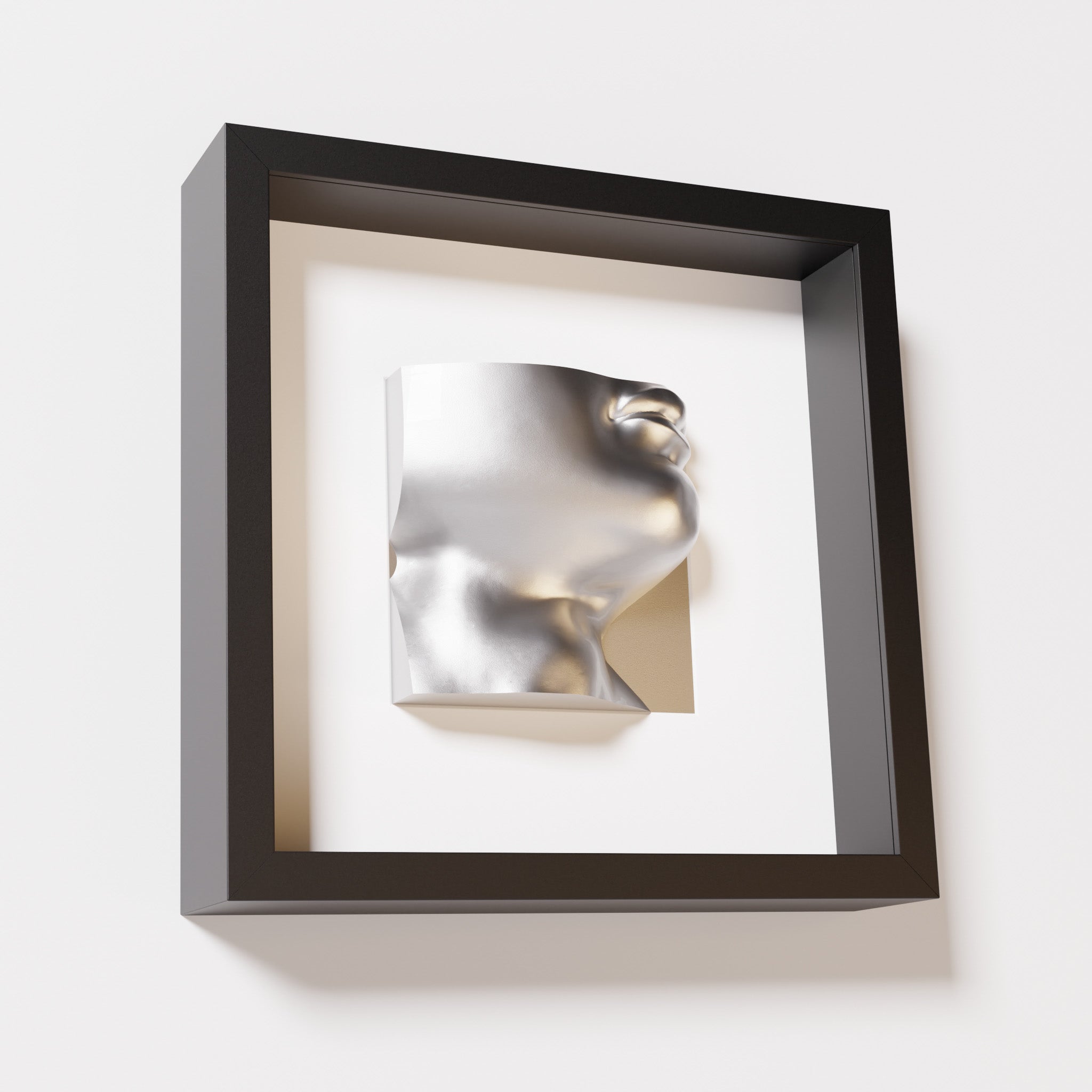 A close-up of a black shadowbox frame containing a chrome silver sculpture of 'David's Lip,' highlighting the detailed lips, chin, and reflective silver finish inspired by Michelangelo's David.