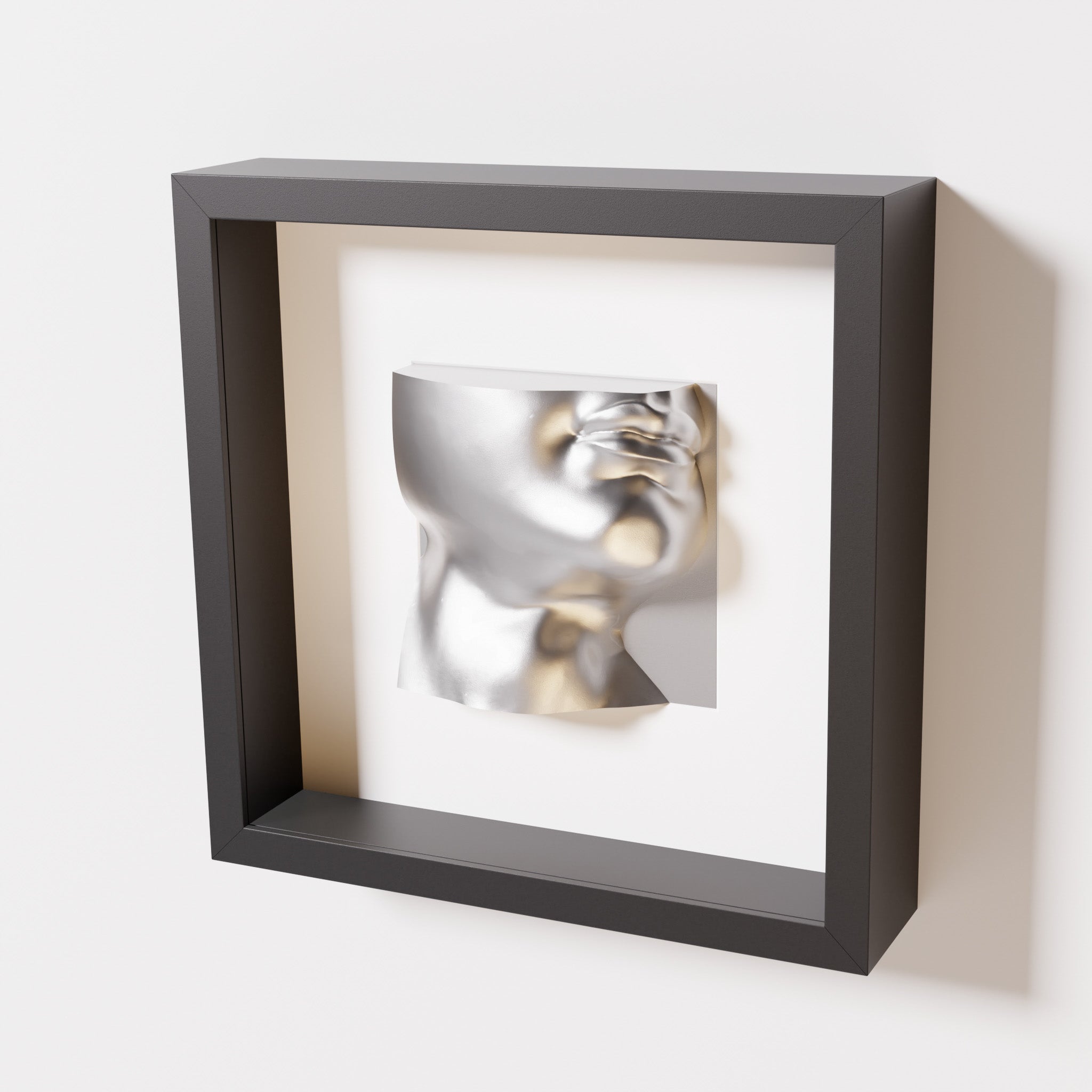 A close-up of a black shadowbox frame containing a chrome silver sculpture of 'David's Lip,' highlighting the detailed lips, chin, and reflective silver finish inspired by Michelangelo's David.