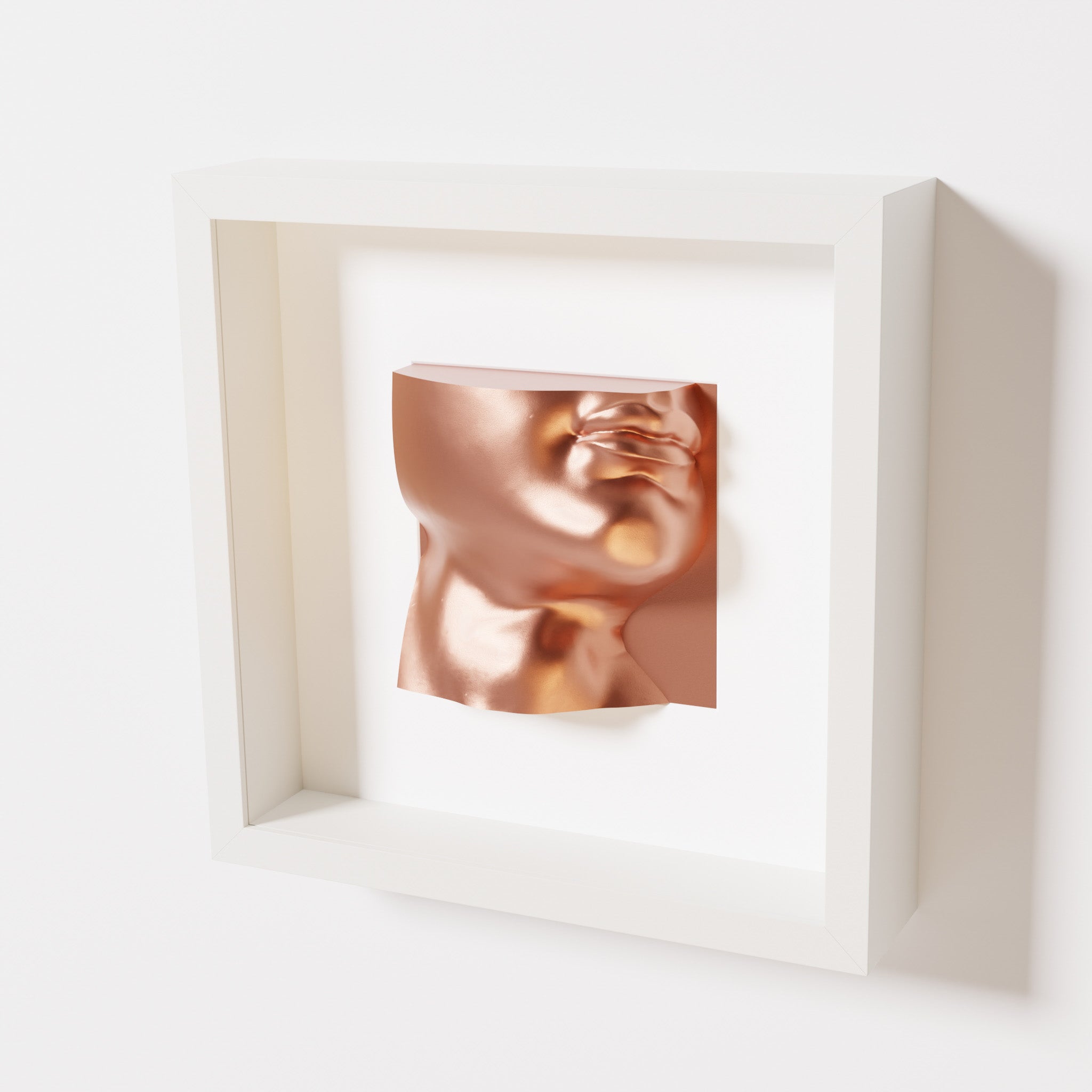 A close-up of a white shadowbox frame containing a chrome copper sculpture of 'David's Lip,' highlighting the detailed lips, chin, and reflective copper finish inspired by Michelangelo's David.