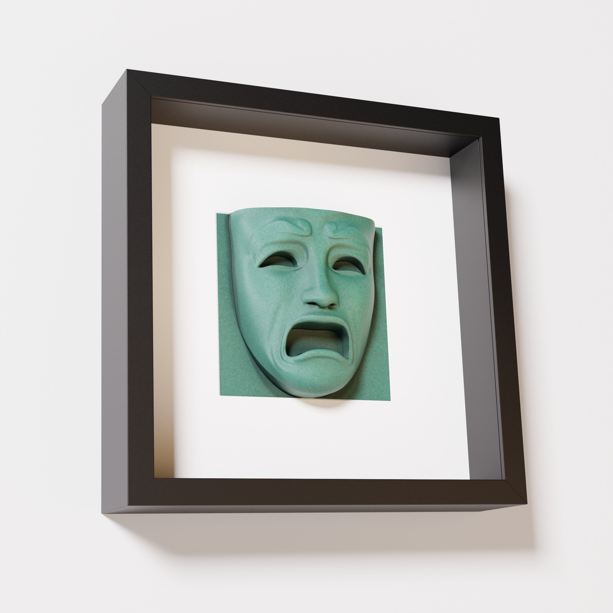 A close-up of a black shadowbox frame containing an old patina sculpture of 'Despair,' showcasing the expressive mask with furrowed brows, hollow eyes, and an open mouth.