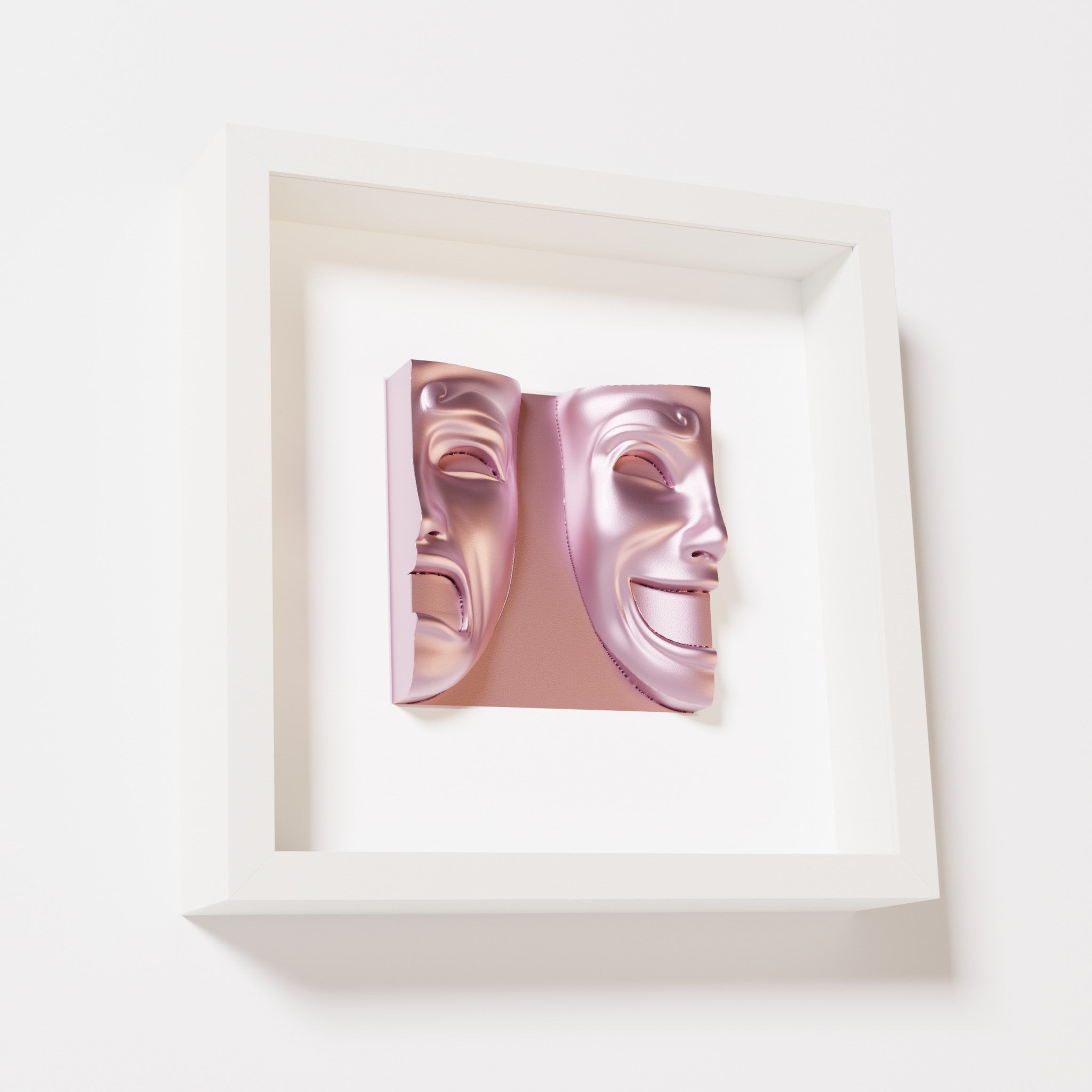 A close-up of a white shadowbox frame containing a metallic rose sculpture of 'Despair & Joy,' showcasing two expressive masks side by side: one with a sorrowful expression and the other with a joyful smile.