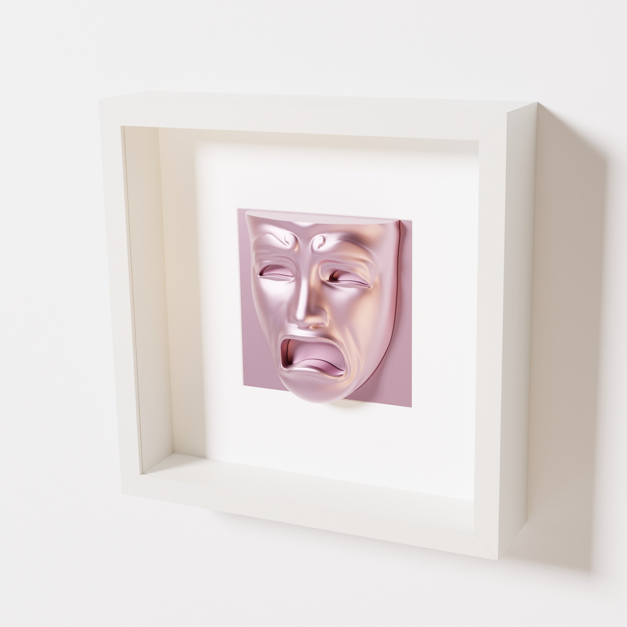 A close-up of a white shadowbox frame containing a metallic rose sculpture of 'Despair,' showcasing the expressive mask with furrowed brows, hollow eyes, and an open mouth.