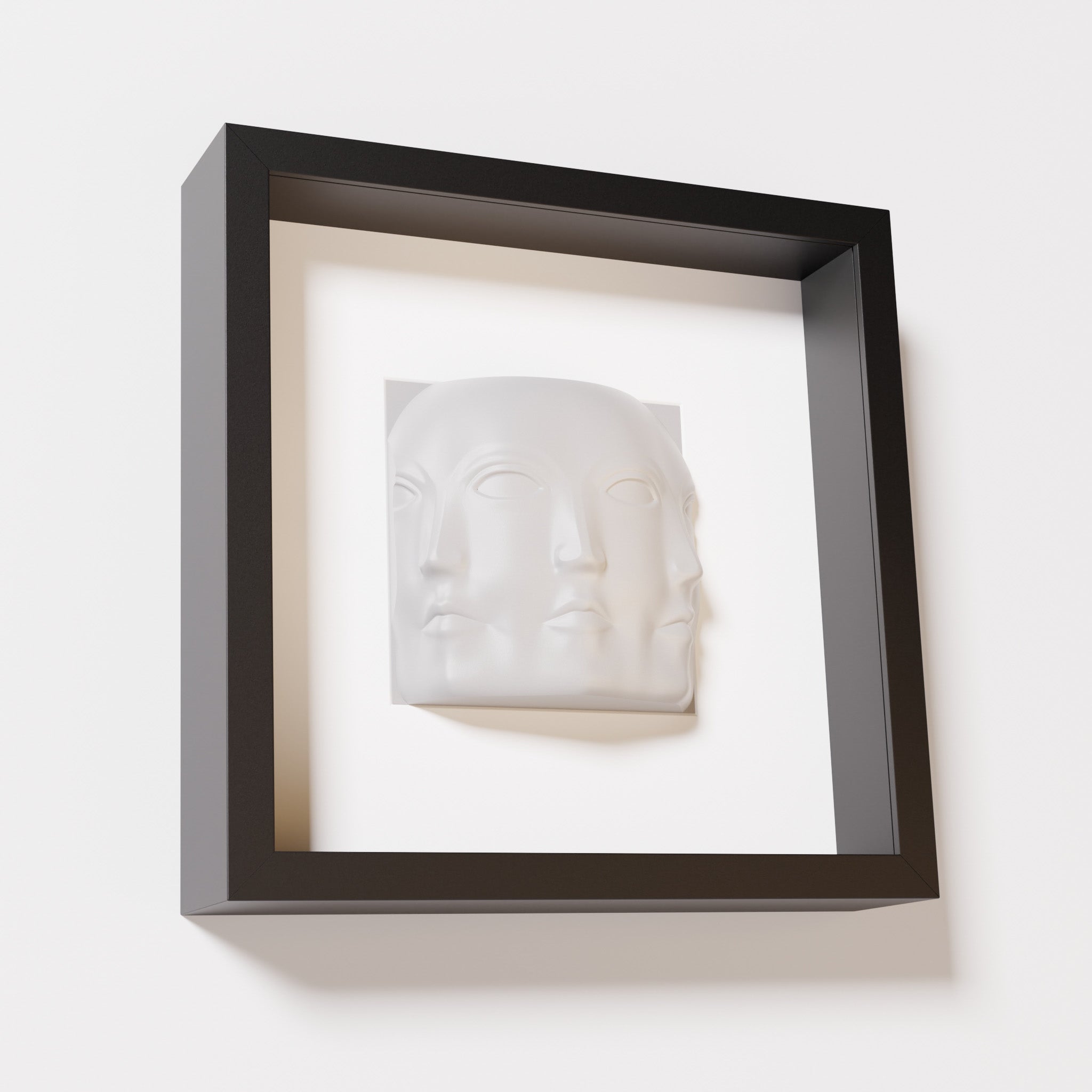 A close-up of a black shadowbox frame containing a marble white sculpture of 'Dora,' featuring three interconnected faces merging at the edges, creating a surreal and multi-dimensional effect.