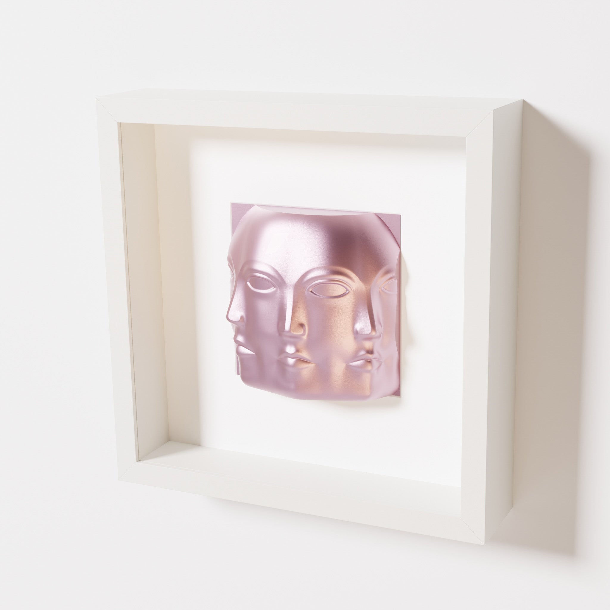 A close-up of a white shadowbox frame containing a metallic rose sculpture of 'Dora,' featuring three interconnected faces merging at the edges, creating a surreal and multi-dimensional effect.