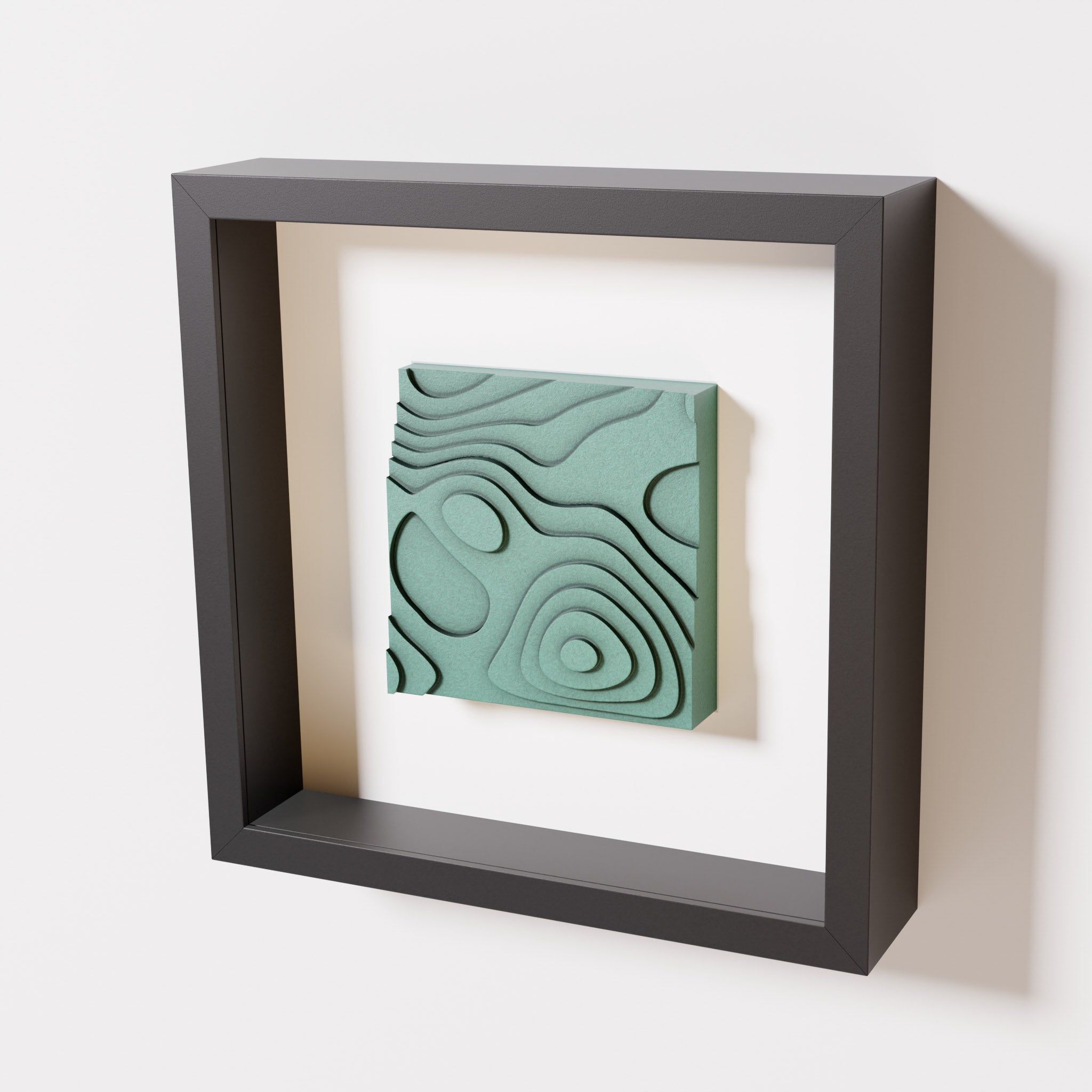 A close-up of a black shadowbox frame containing an old patina artwork depicting layered contour lines inspired by geographic elevation levels, showcasing intricate and geometric details with a textured green finish.