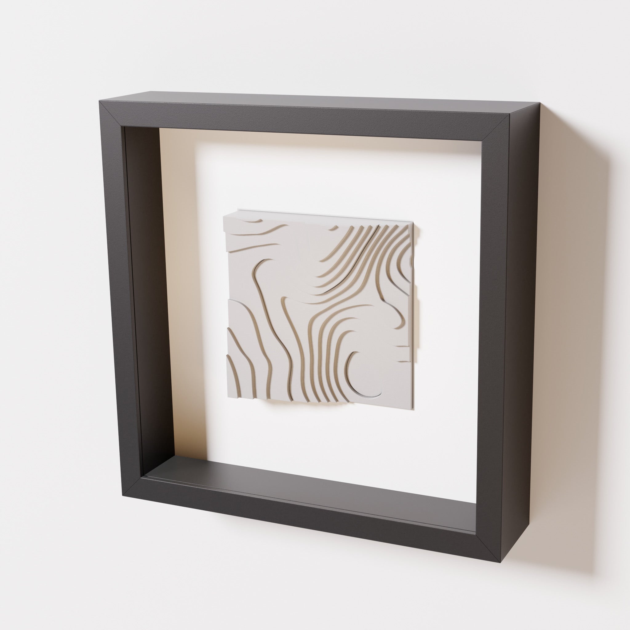 A close-up of a black shadowbox frame containing a marble white artwork depicting flowing contour lines inspired by geographic elevation levels, showcasing intricate geometric details.