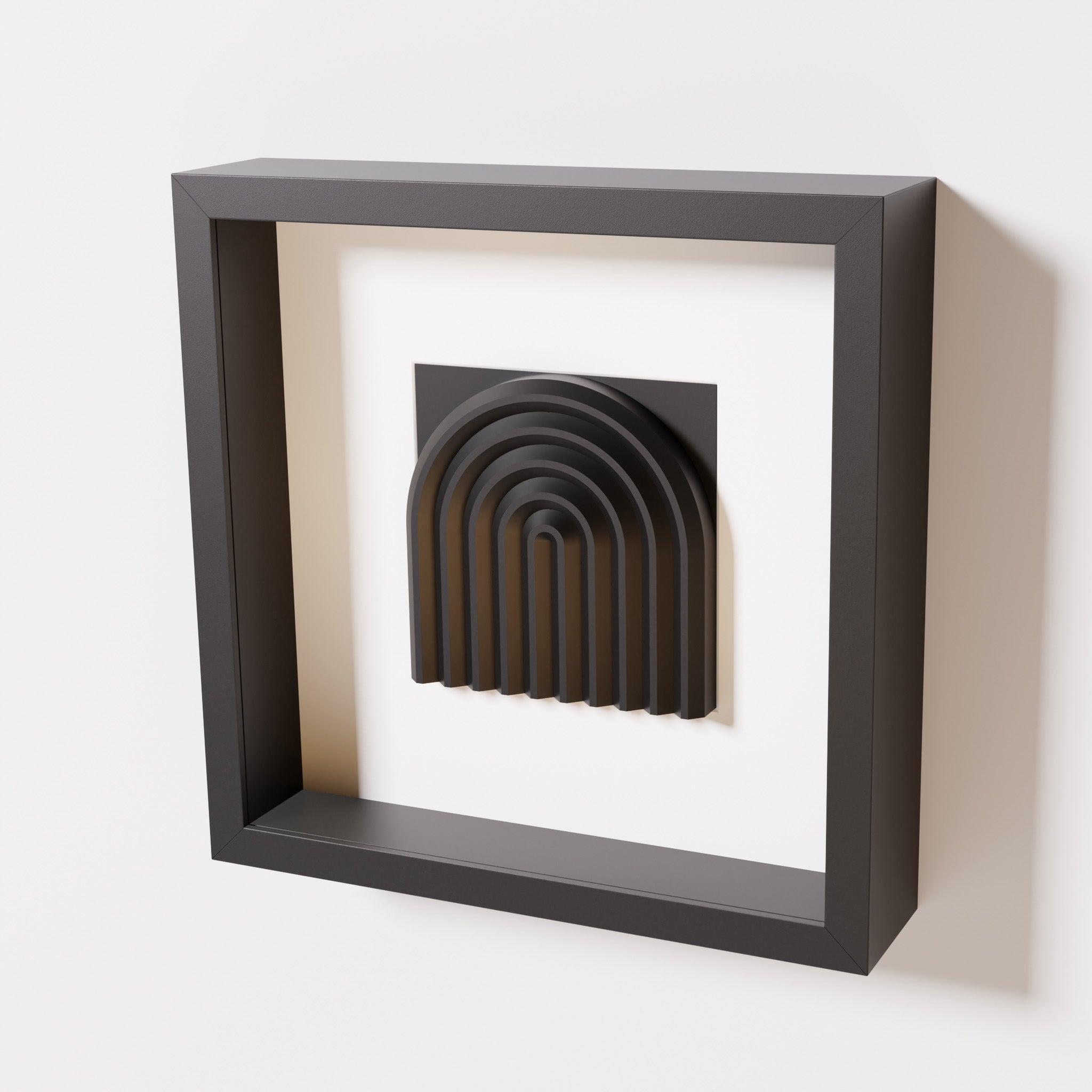 A close-up of a black shadowbox frame containing a matte black artwork featuring the gentle arc of a rainbow design, showcasing its smooth, layered texture and intricate curvature.