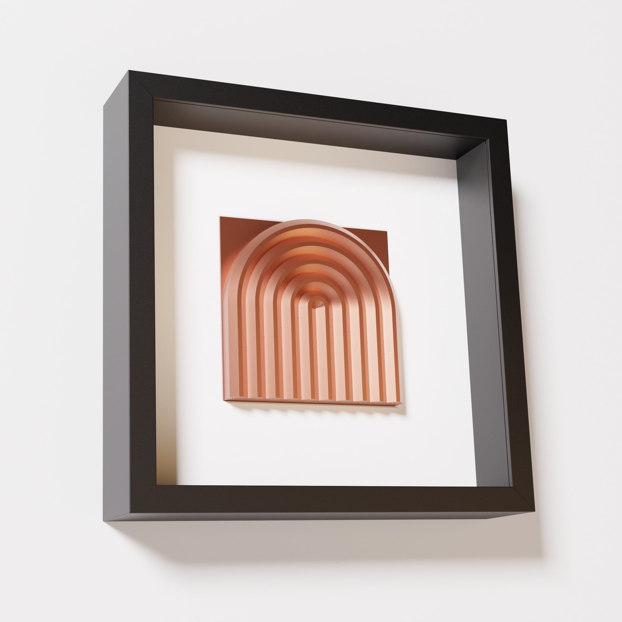 A close-up of a black shadowbox frame containing a chrome copper artwork featuring the gentle arc of a rainbow design, showcasing its shiny copper highlights and layered textures.