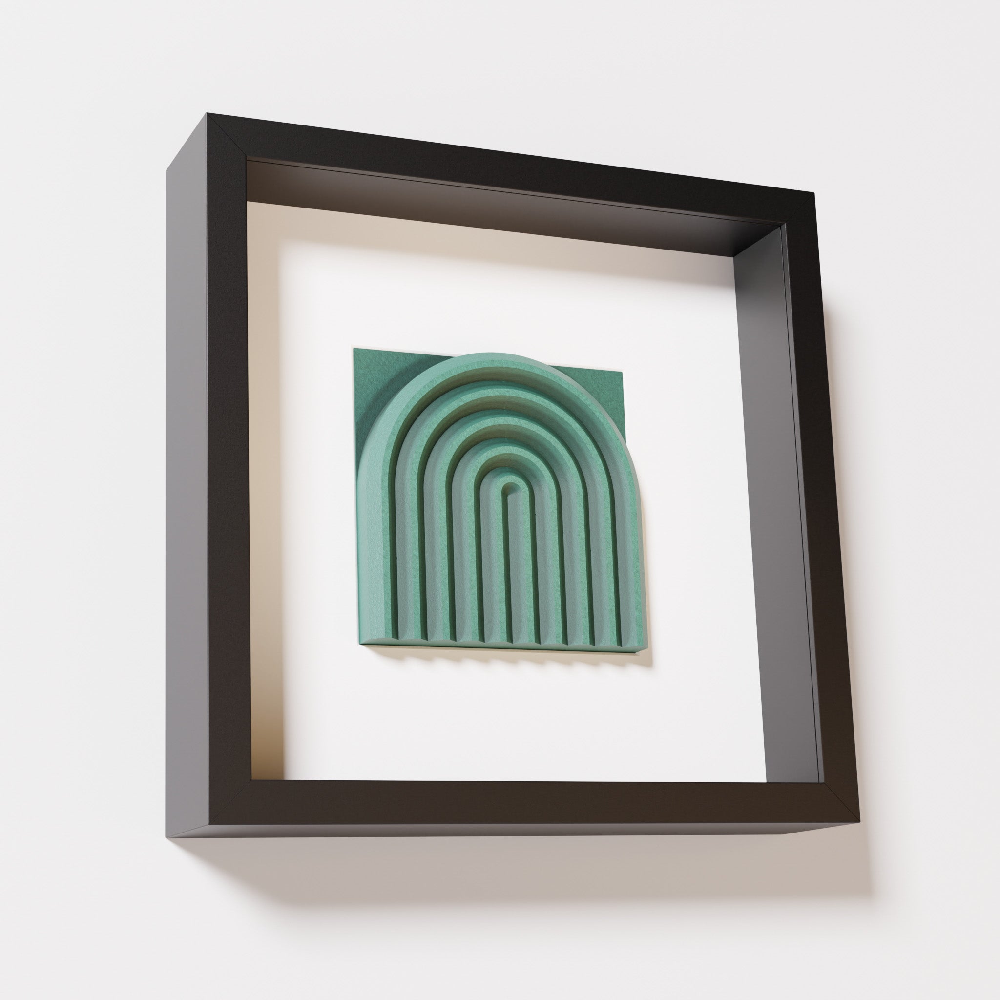 A close-up of a black shadowbox frame containing an old patina artwork featuring the gentle arc of a rainbow design, showcasing its textured green finish and detailed layering.