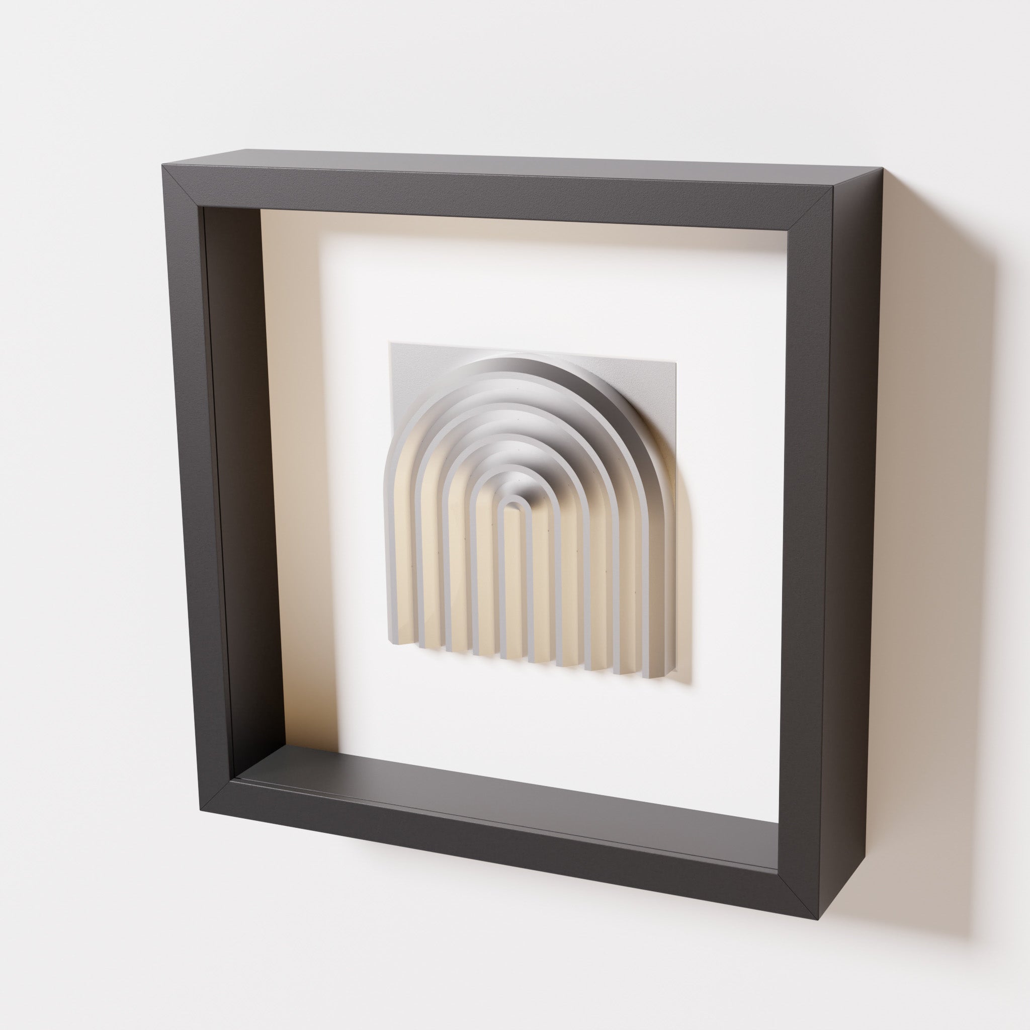 A close-up of a black shadowbox frame containing a chrome silver artwork featuring the gentle arc of a rainbow design, showcasing its reflective silver highlights and elegant curves.