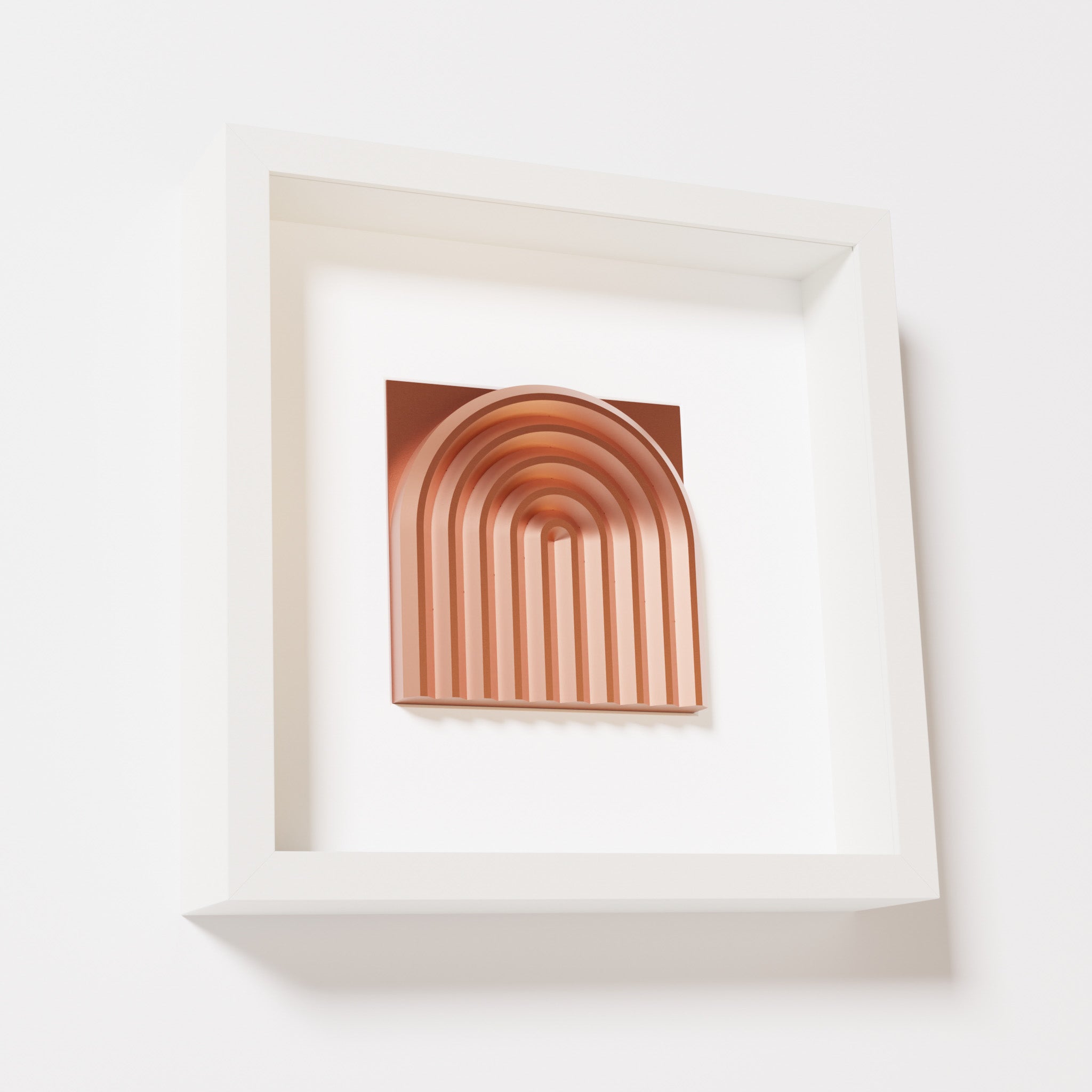 A close-up of a white shadowbox frame containing a chrome copper artwork featuring the gentle arc of a rainbow design, showcasing its shiny copper highlights and layered textures.