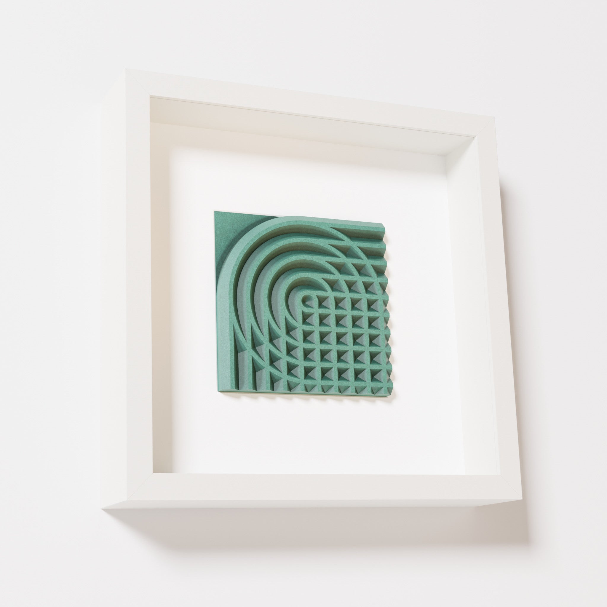 A close-up of a white shadowbox frame containing an old patina artwork featuring the elegant arcs and geometric grid of 'Rainbow II,' showcasing a textured green finish.