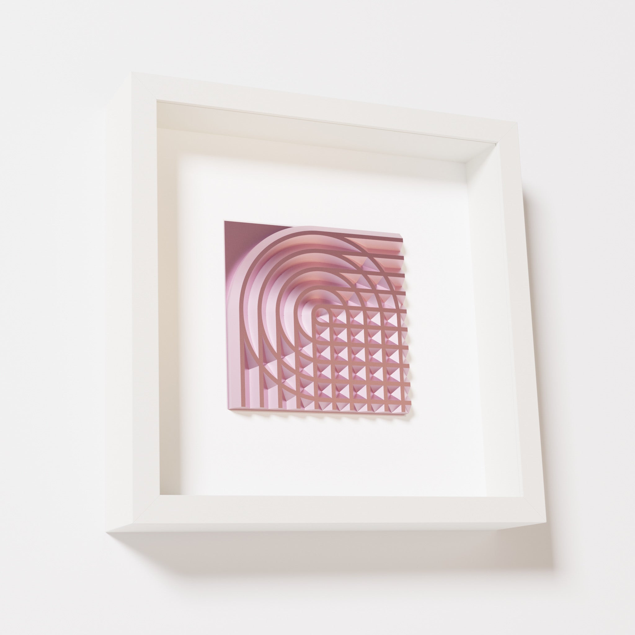 A close-up of a white shadowbox frame containing a metallic rose artwork featuring the elegant arcs and geometric grid of 'Rainbow II,' showcasing reflective pink highlights.