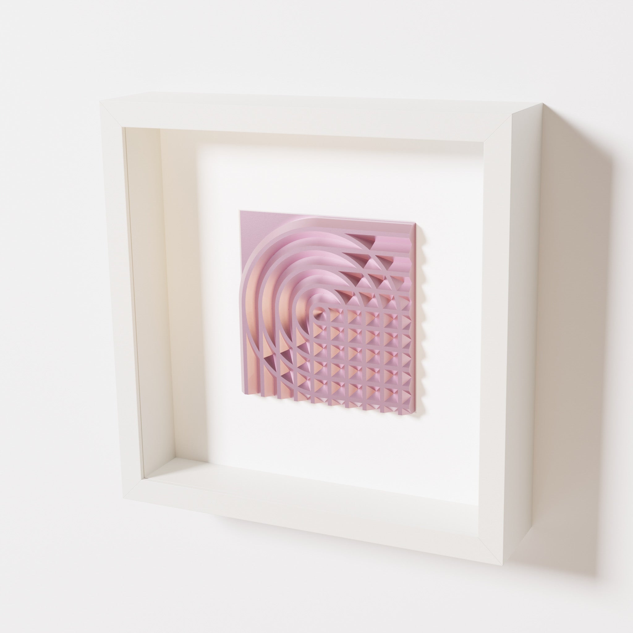 A close-up of a white shadowbox frame containing a metallic rose artwork featuring the elegant arcs and geometric grid of 'Rainbow II,' showcasing reflective pink highlights.