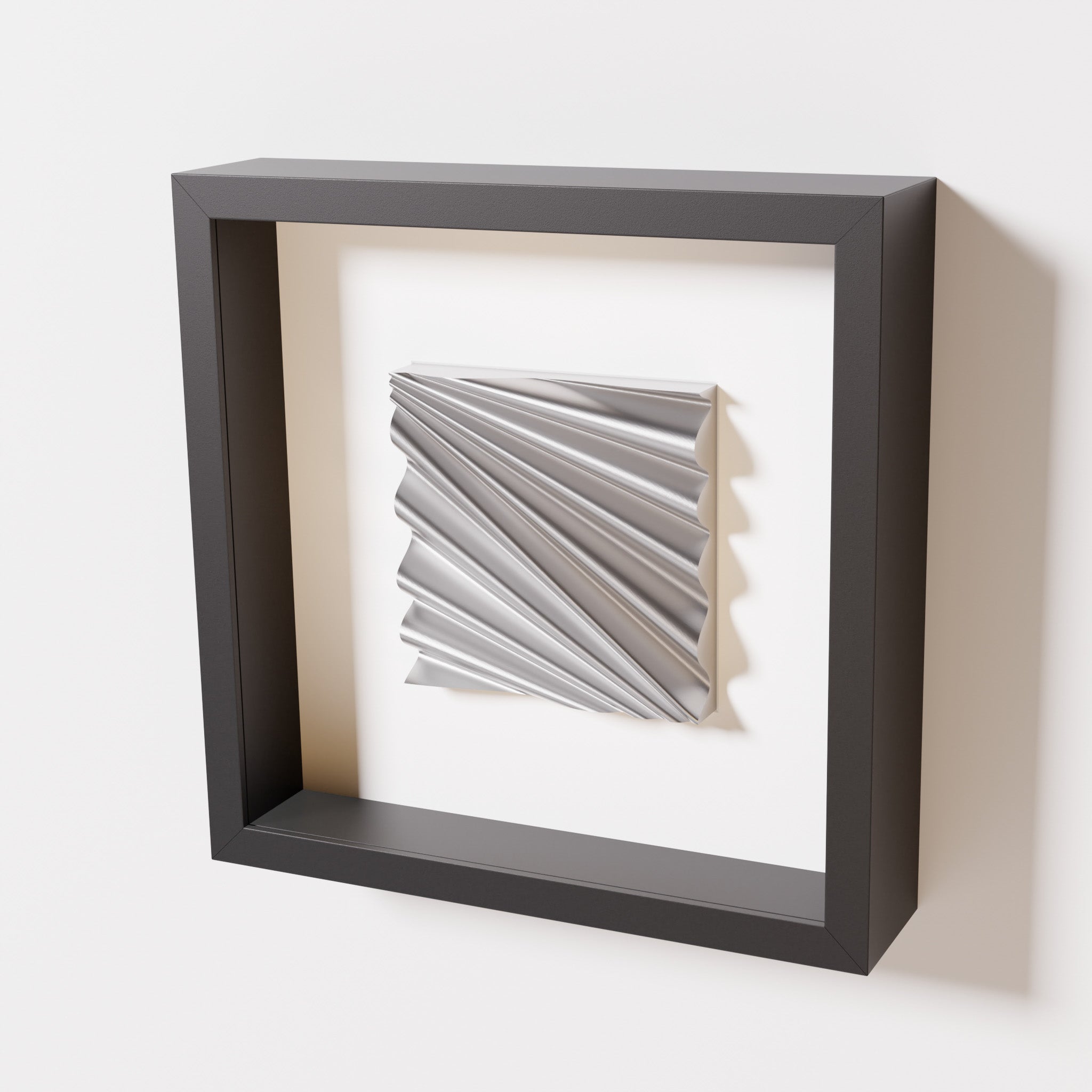 A close-up of a black shadowbox frame containing a chrome silver artwork featuring the rhythmic crests and troughs of 'Wave,' showcasing reflective silver highlights.