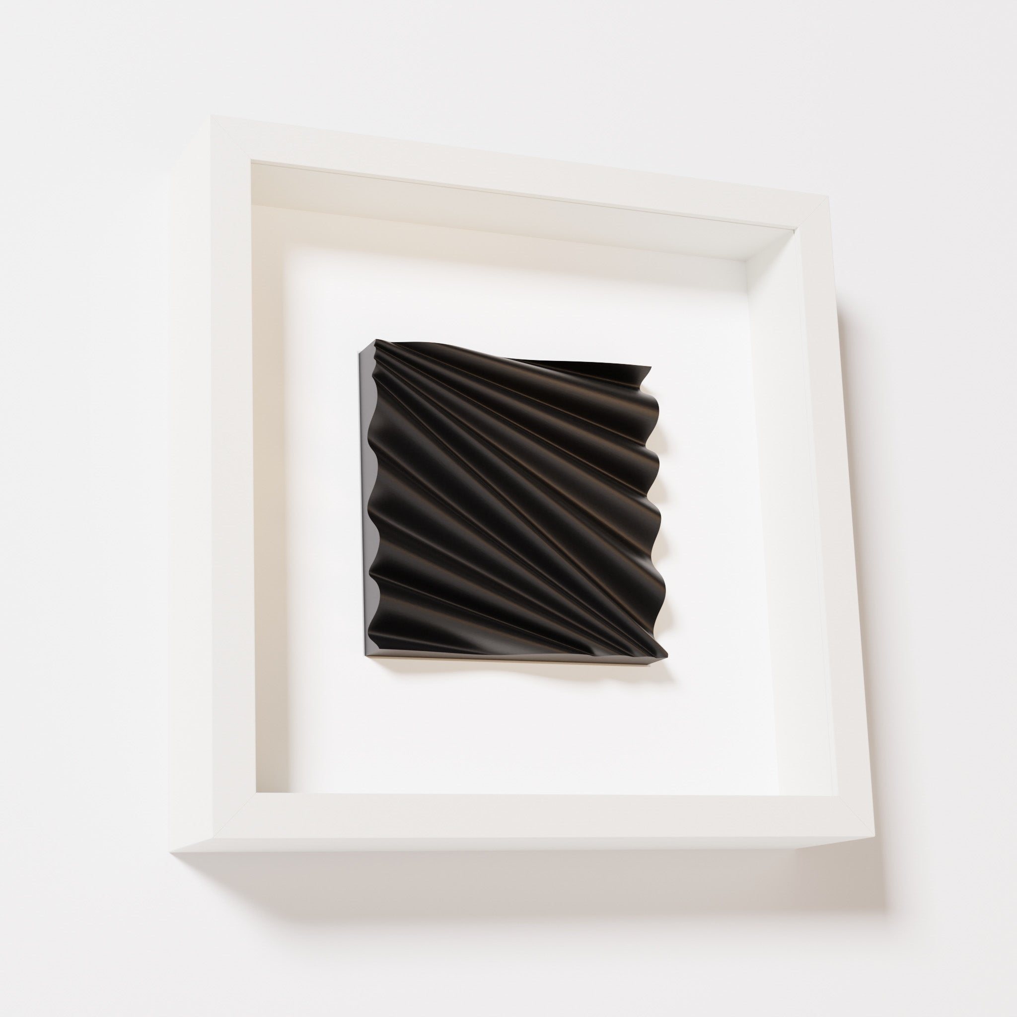 A close-up of a white shadowbox frame containing a matte black artwork featuring the rhythmic crests and troughs of 'Wave,' emphasizing its intricate texture and dynamic design.