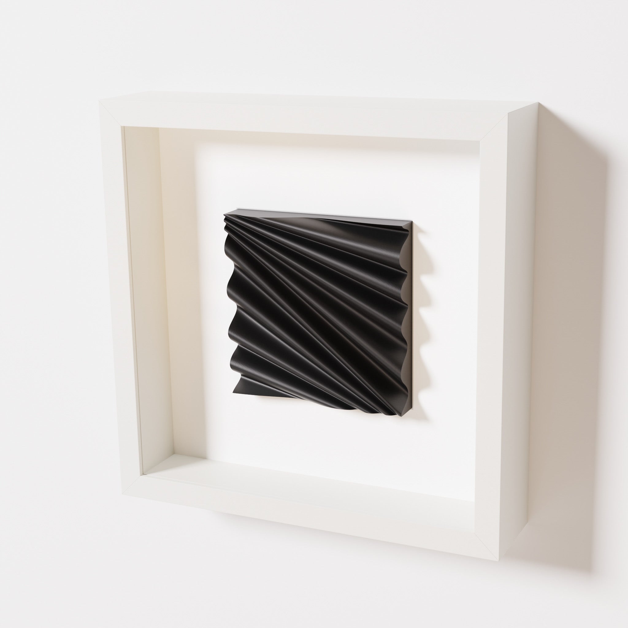 A close-up of a white shadowbox frame containing a matte black artwork featuring the rhythmic crests and troughs of 'Wave,' emphasizing its intricate texture and dynamic design.