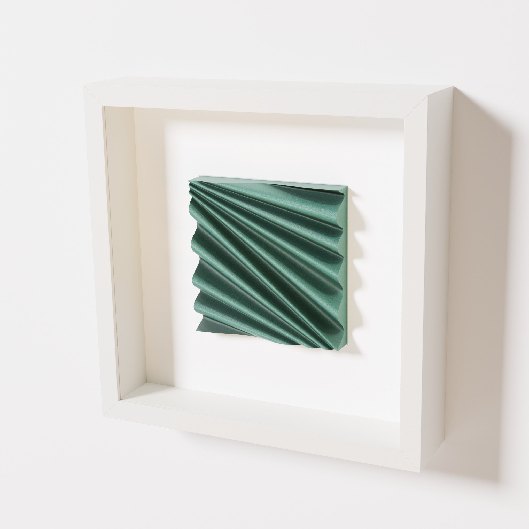 A close-up of a white shadowbox frame containing an old patina artwork featuring the rhythmic crests and troughs of 'Wave,' showcasing a textured green finish and intricate detail.