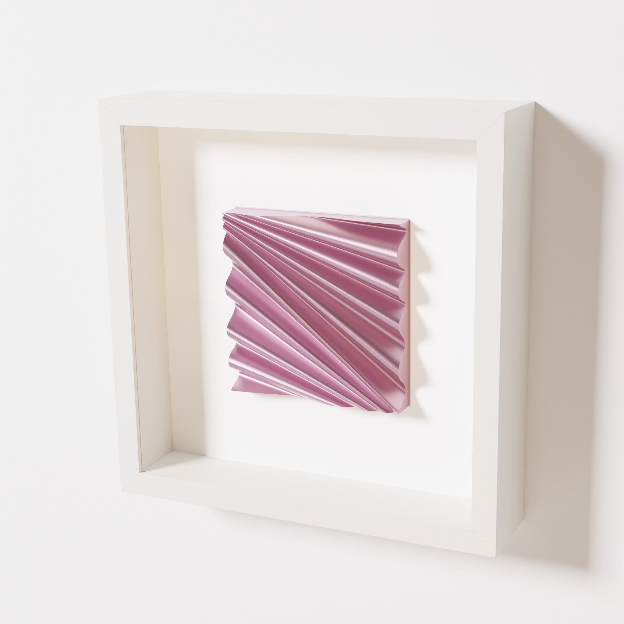 A close-up of a white shadowbox frame containing a metallic rose artwork featuring the rhythmic crests and troughs of 'Wave,' showcasing reflective pink highlights.