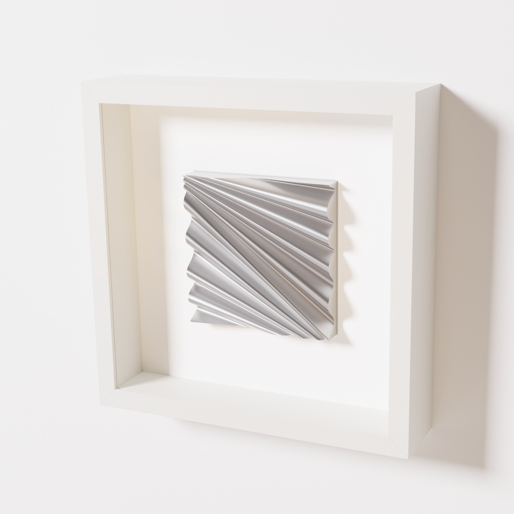 A close-up of a white shadowbox frame containing a chrome silver artwork featuring the rhythmic crests and troughs of 'Wave,' showcasing reflective silver highlights.