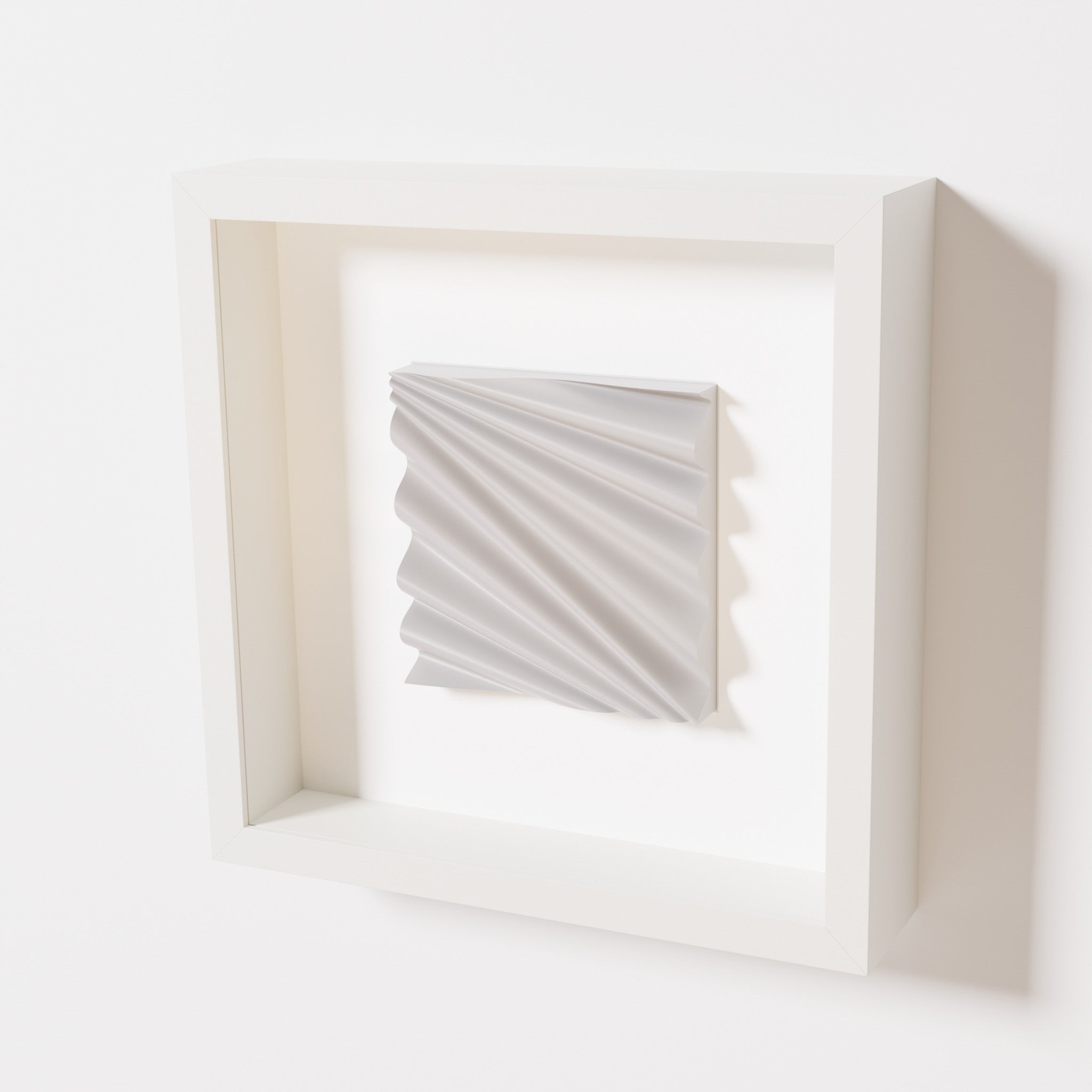 A close-up of a white shadowbox frame containing a marble white artwork featuring the rhythmic crests and troughs of 'Wave,' emphasizing its smooth texture and dynamic design.